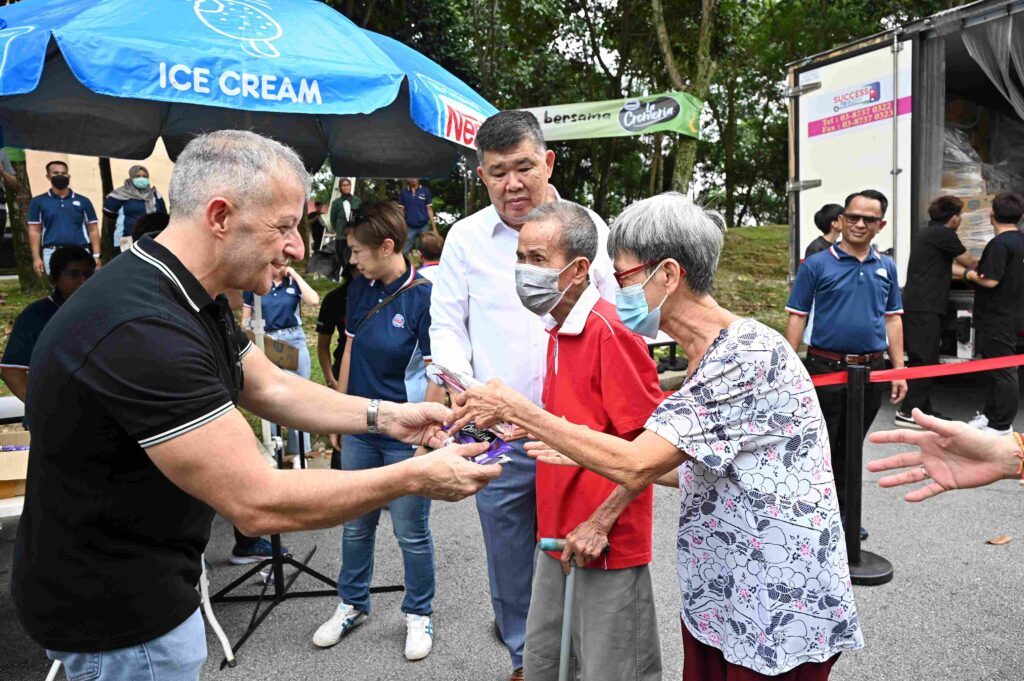 Juan Aranols and [Centre] Uncle Kentang personally handing out Nestlé LA CREMERIA ice cream sticks to more than 10,000 families in celebration of the Raya festival